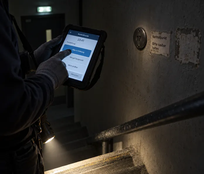 Hände erfassen den Kontrollgang im Treppenhaus direkt auf dem Gerät