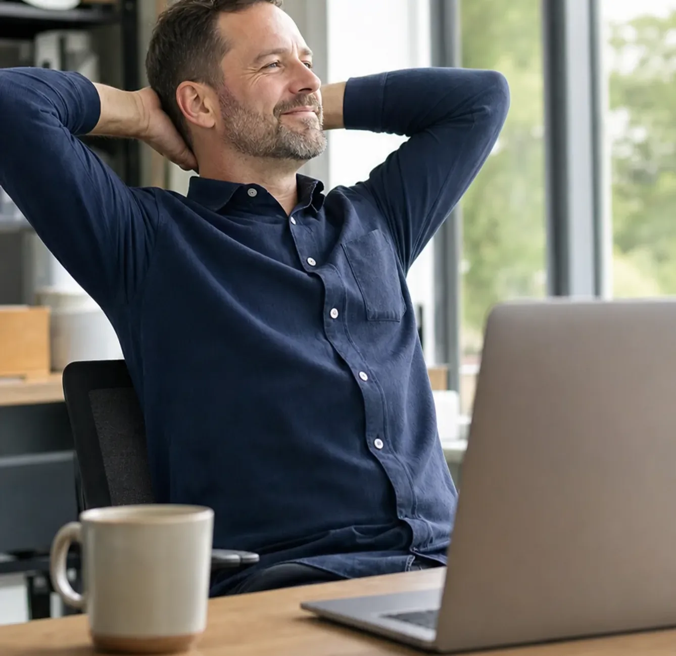Mitarbeiter arbeitet zufrieden am Laptop
