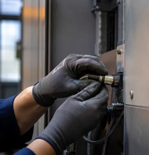 Datenkabel wird an den Schaltschrank einer Maschine gesteckt
