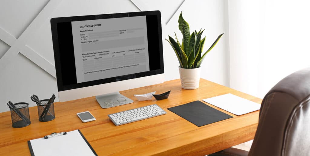 Schreibtisch mit einem iMac mit Formular, Tastatur und einer Pflanze