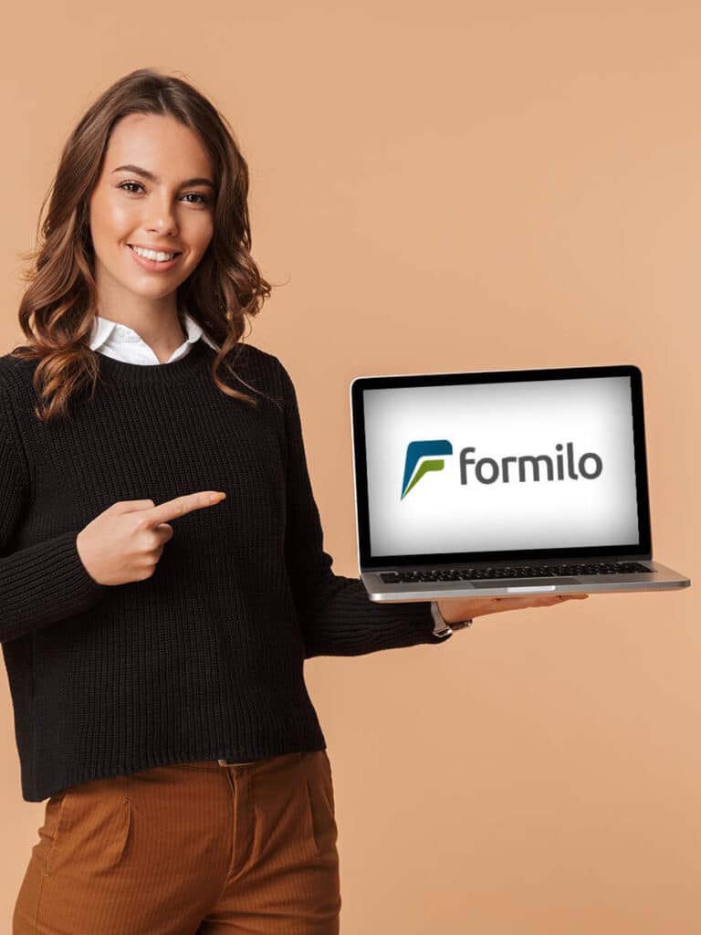 Lächelnde Frau zeigt mit dem Finger auf ihren Laptop mit dem Formilo Logo