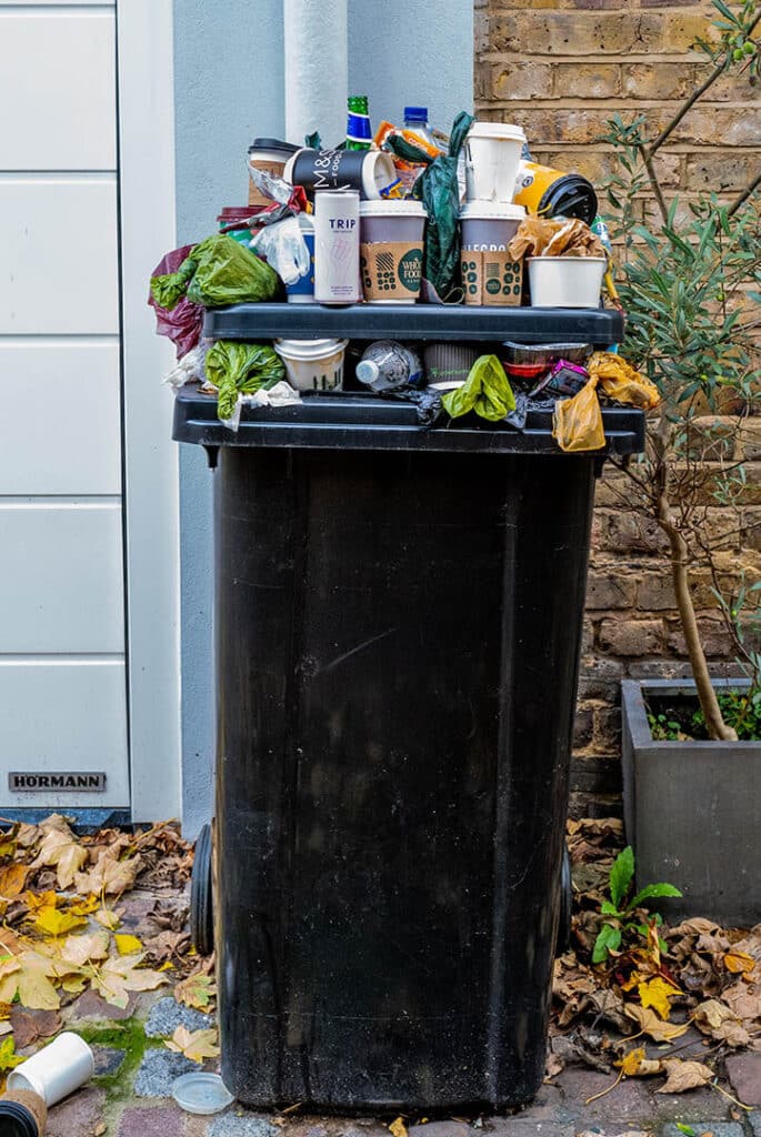 Fotos eines überfüllten Müllbehälters vor Mietshaus