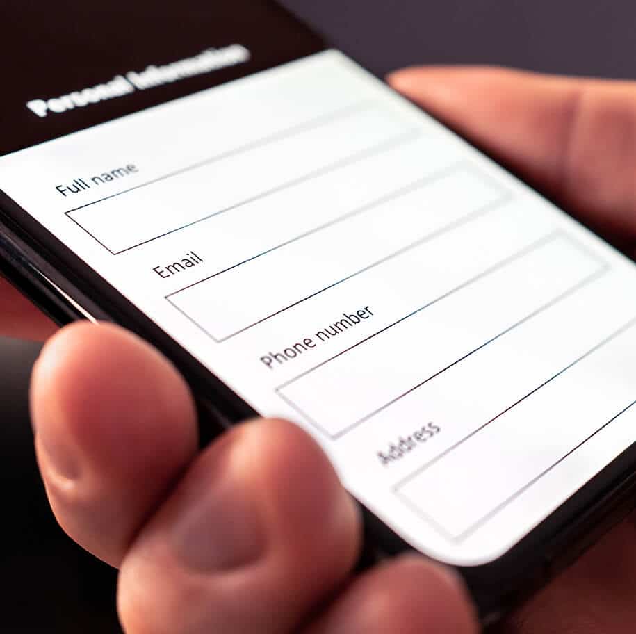 Mann hält Smartphone mit geöffnetem Formular