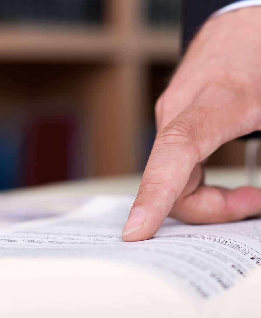 Anzugträger verweist auf Gesetz im Gesetzesbuch