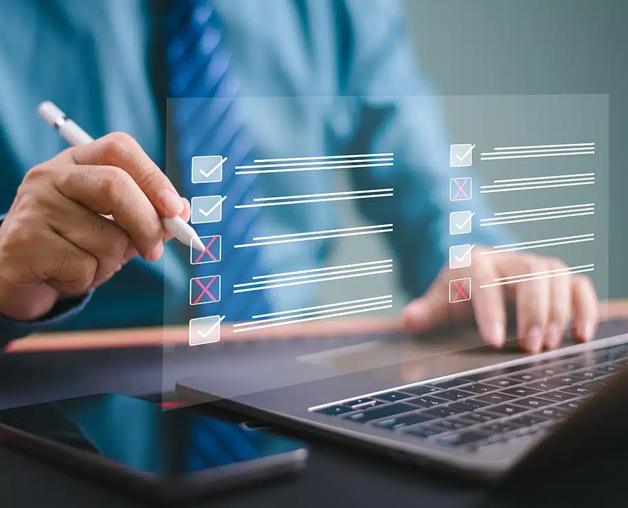 Geschäftsmann nutzt einen Laptop für Häckchen setzen an einer Online-Checkliste.