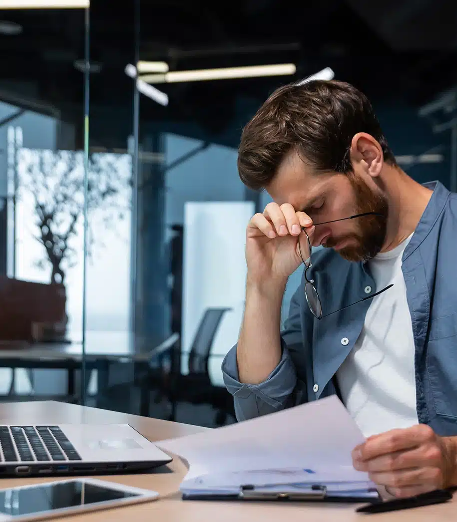 Verärgerter Geschäftsmann hinter Papierkram im modernen Büro