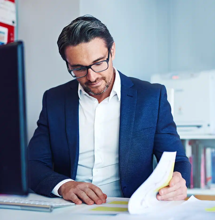 Mann sitzt im Büro und arbeitet an Dokumenten