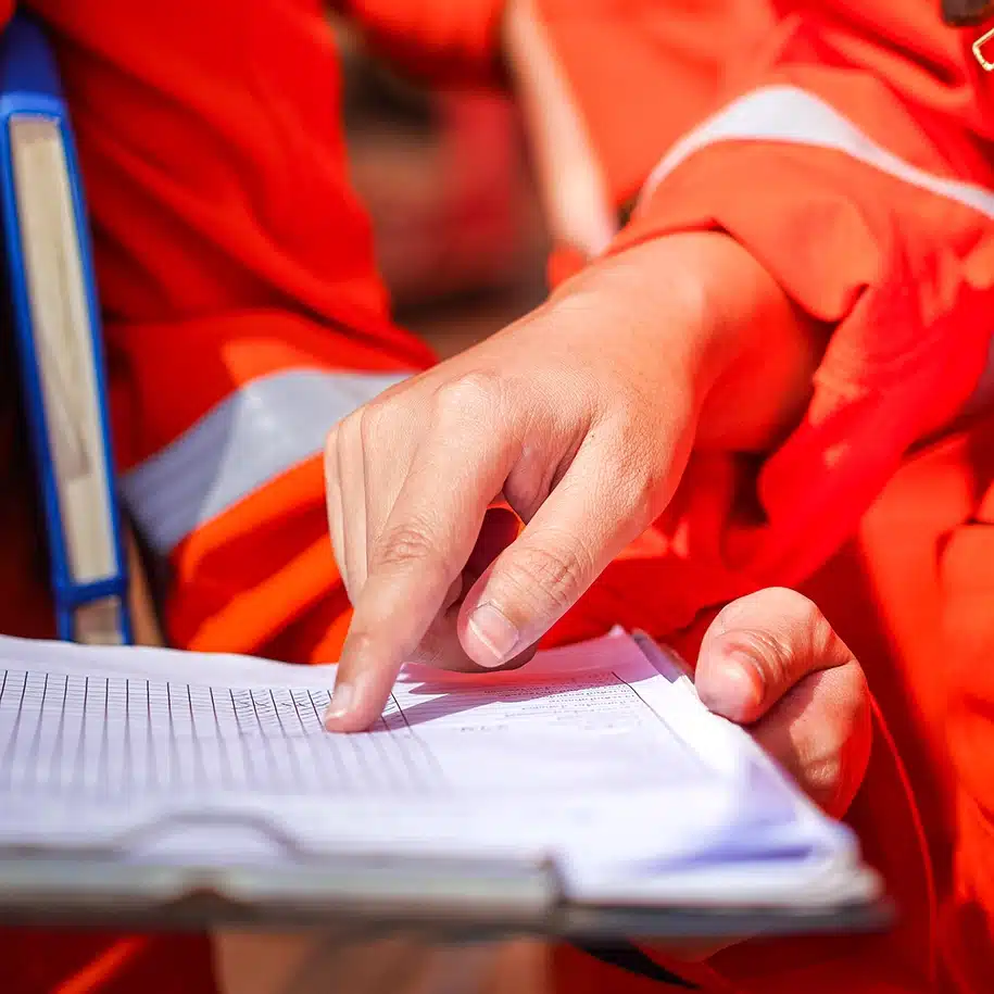 Zwei Arbeiter in Sicherheitskleidung besprechen ein Dokument