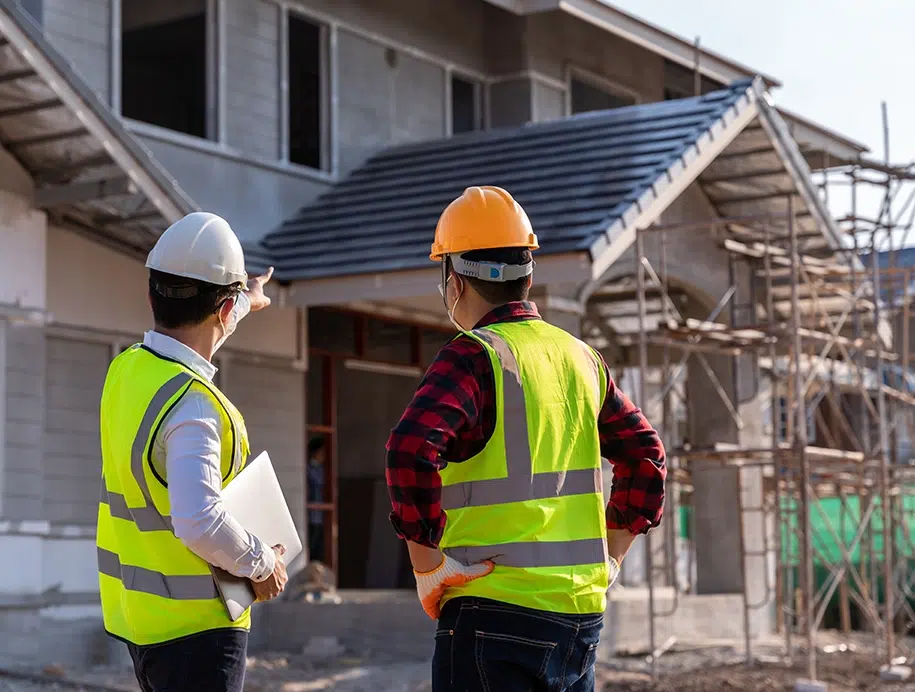 Zwei Bauarbeiter beurteilen eine Baustelle