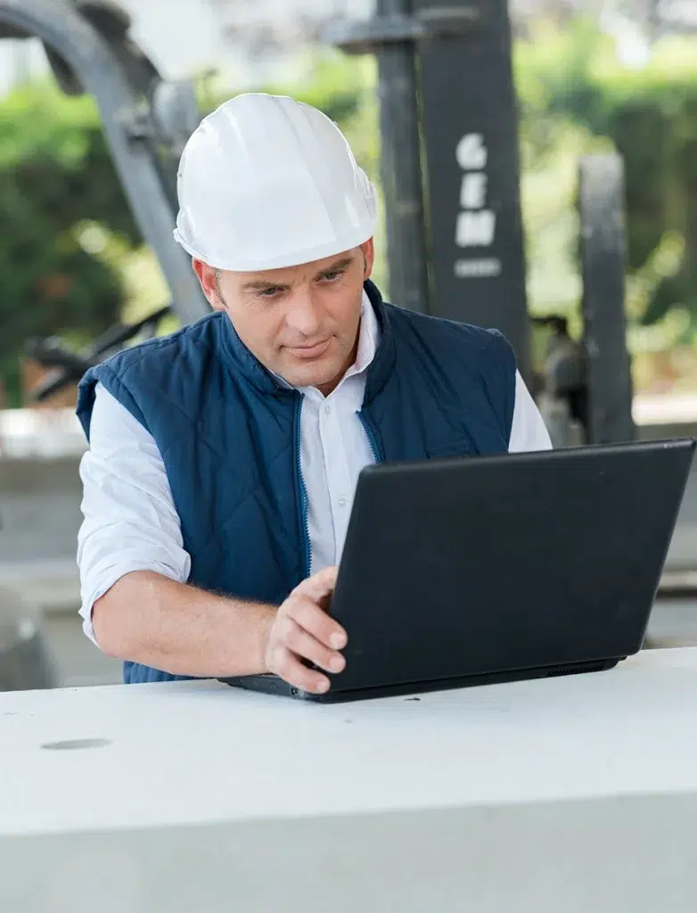 Arbeiter schaut auf Laptop und führt Aufträge durch