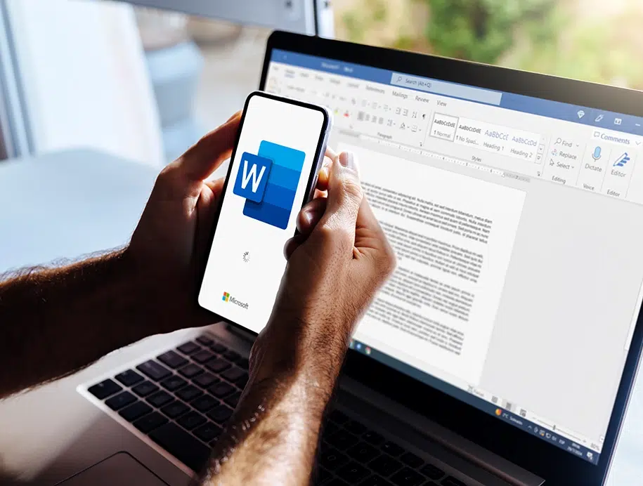 Mann benutzt ein Mobiltelefon mit dem Microsoft Word-Logo auf dem Bildschirm.