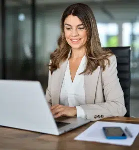 Geschäftsfrau im Büro, die bei der Arbeit einen Laptop verwendet