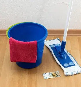 Putzutensilien und etwas Gleingeld symbolisieren eine Minijob