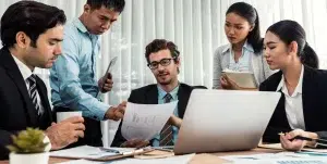 Eine vielfältige Gruppe von Finanzleuten analysiert Finanzdaten auf einem Bürotisch.