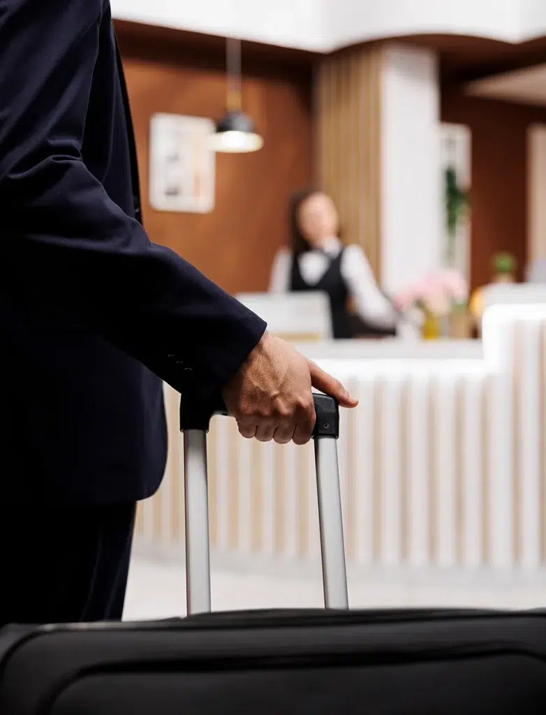 Hotelgast betritt mit Gepäck die Rezeption.
