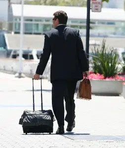 Geschäftmann im Anzug mit Gepäck führt eine Geschäftsreise