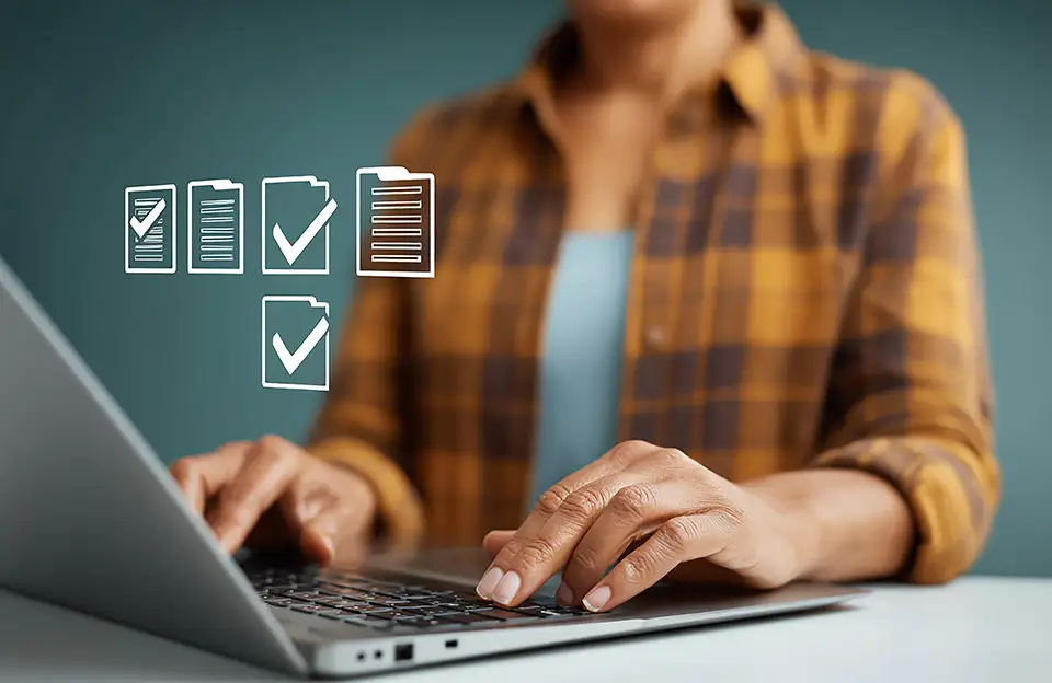 Eine Person im Karohemd sitzt vor einem mehrsprachigen Formular am Laptop