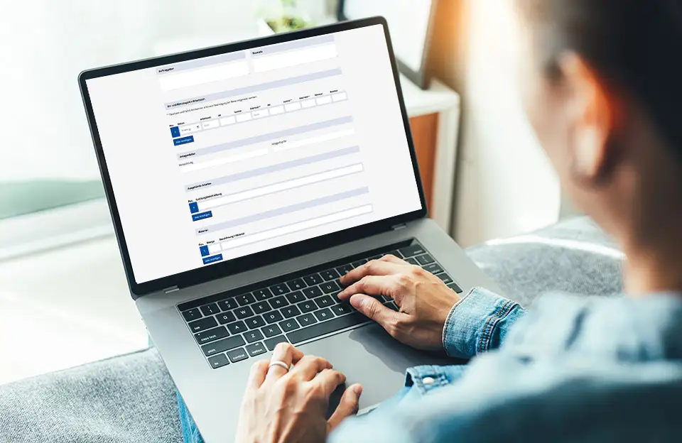 Eine Frau beim Ausfüllen eines HTML Formulars am Laptop