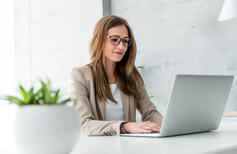 Eine junge Geschäftsfrau arbeitet an einem Laptop