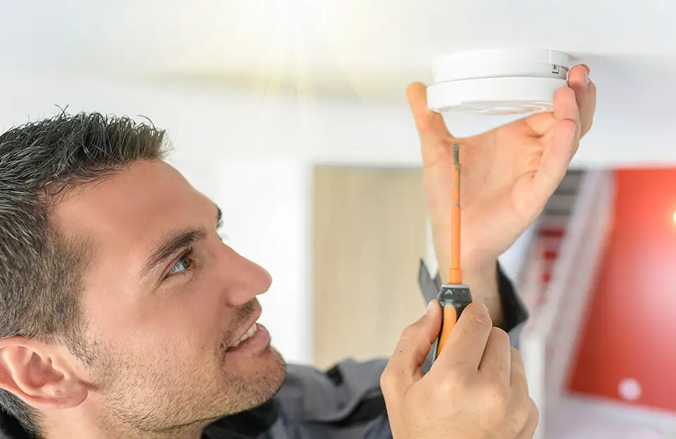 Ein Techniker bei der Rauchmelder-Wartung