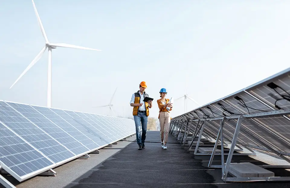 Ein Techniker und eine Technikerin prüfen eine Photovoltaikanlage