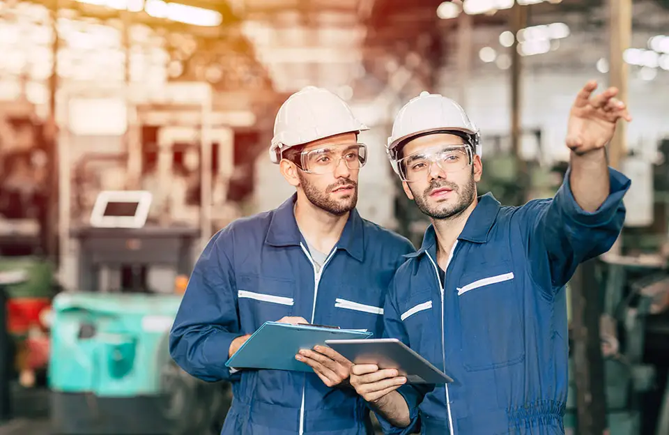 Zwei Handwerker mit Tablet in einem Handwerksbetrieb