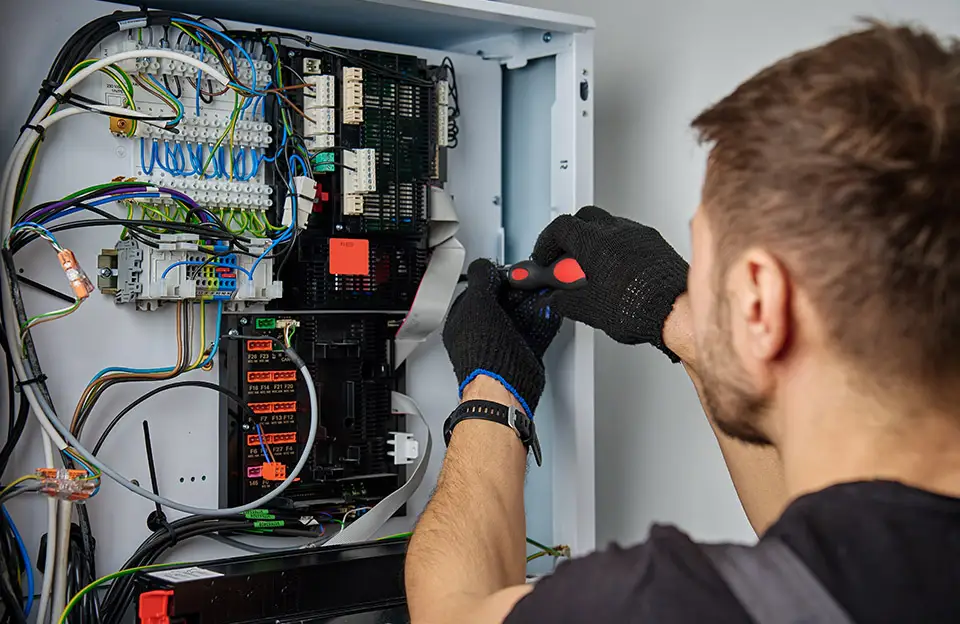 Ein Techniker bei Prüfung und Reparatur einer elektrischen Anlage