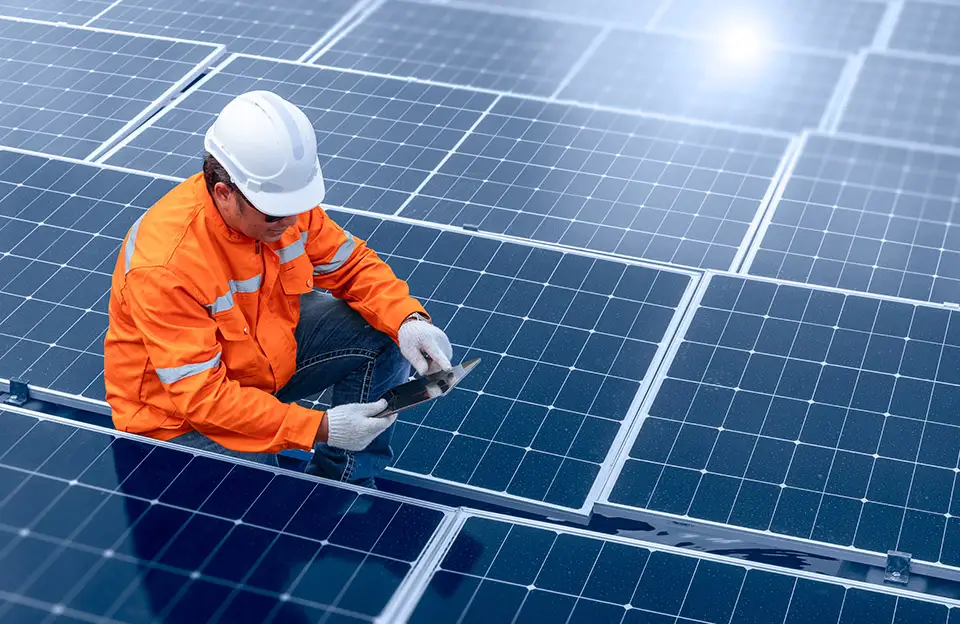 Ein Techniker mit Tablet prüft eine Photovoltaikanlage