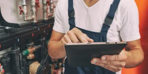Ein Techniker mit Tablet ruft einen Wartungsplan für die Heizung ab