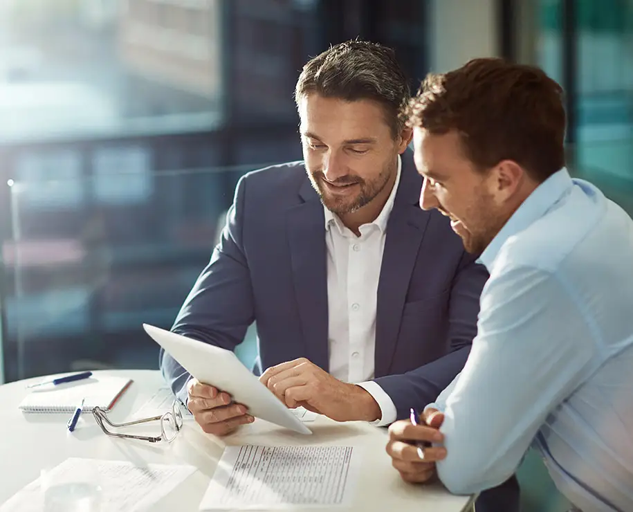 Zwei Geschäftsleute betrachten Formulare auf Papier