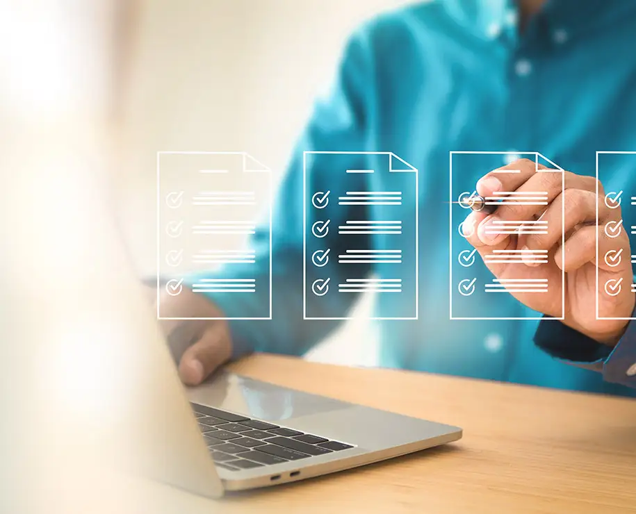 Ein Mann im Hemd mit Formularen auf einem Laptop