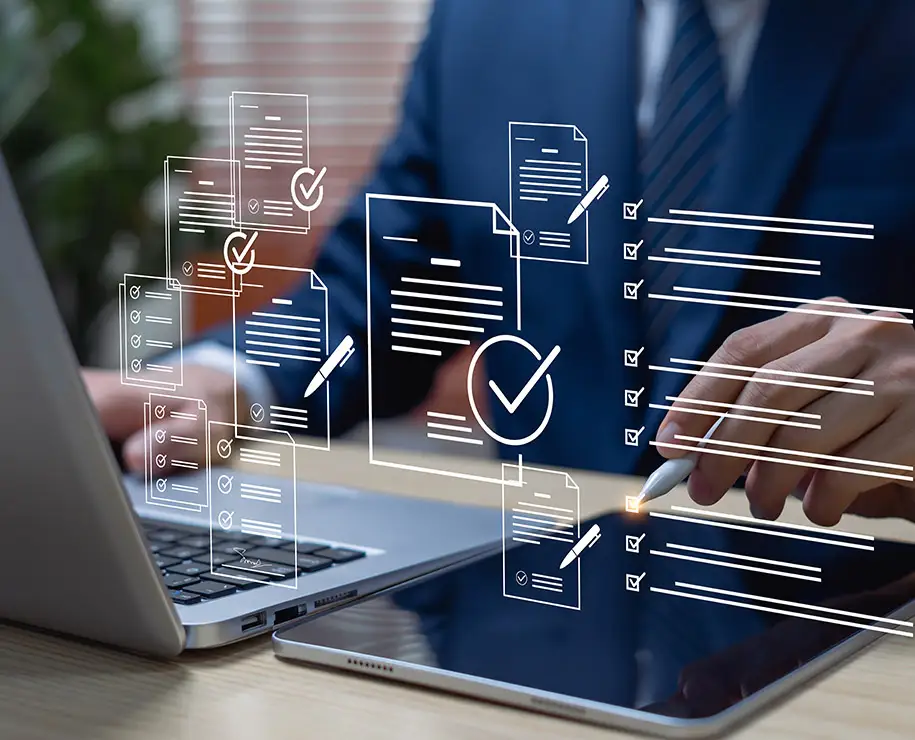 Ein Geschäftsmann mit Tablet und Laptop bei der Arbeit - mit schwebend dargestellten symbolischen Formularen