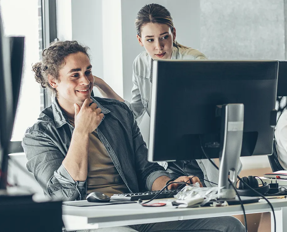 Zwei Personen betrachten zufrieden ein Formular auf eine Monitor