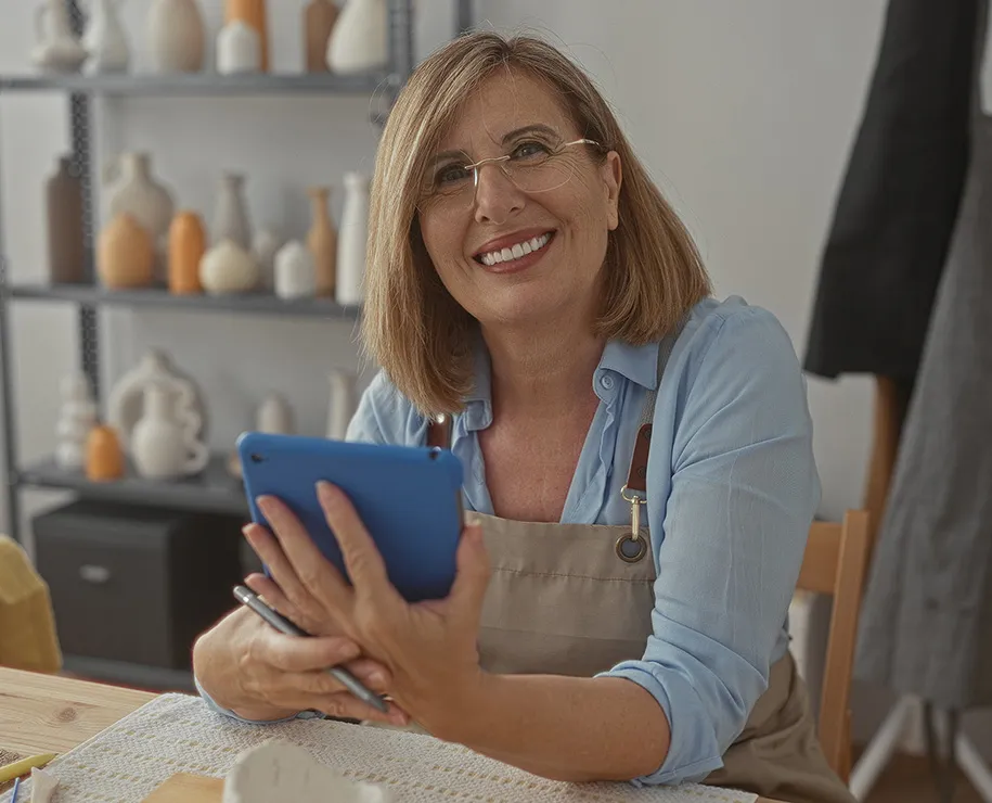 Eine Unternehmerin mit Tablet in ihrer Werkstatt