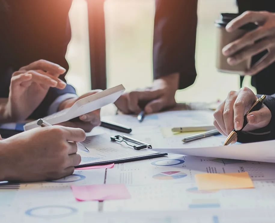 Mehrere Personen bei der Zusammenarbeit über Plänen und Notizen